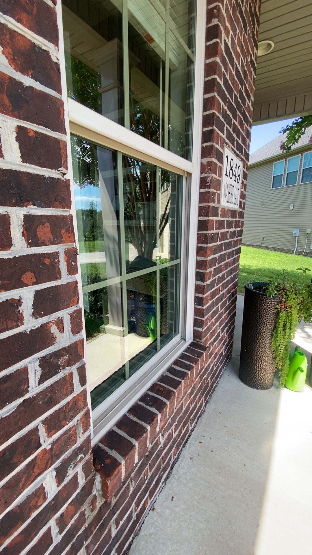 Large clean picture window on a brick home entryway
