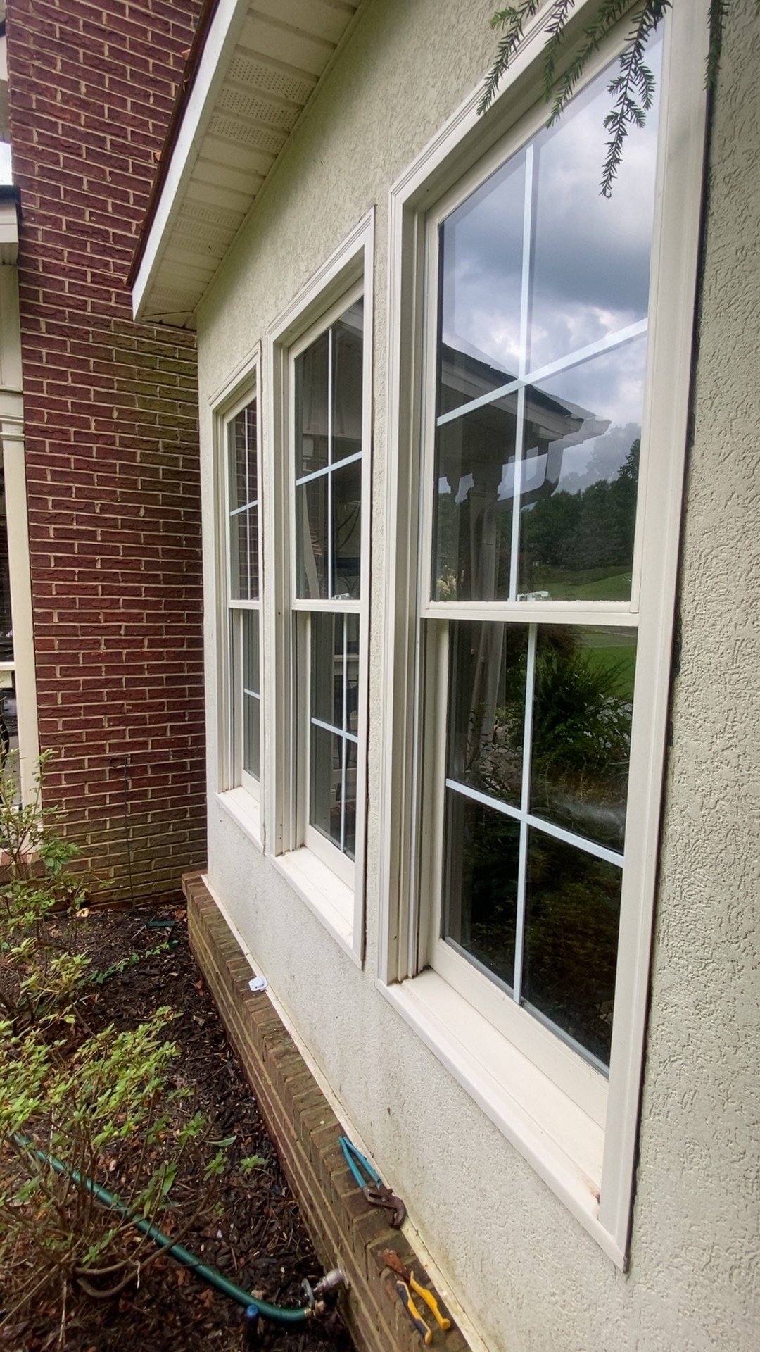 Clean stucco home exterior with three bright windows
